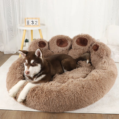 Dog lying on a fluffy brown pet bed with paw-shaped design, surrounded by decorative elements.